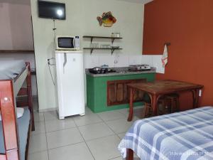 a small kitchen with a small table and a refrigerator at KITNET DO PESCADOR 3 in Imbituba