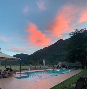 ein Schwimmbad mit Menschen, die neben einem Berg sitzen in der Unterkunft B&B Viridian in Quassolo