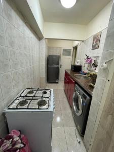a small kitchen with a stove and a refrigerator at sporting sea view two bedroom appartement in Alexandria
