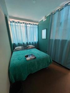 een slaapkamer met een groen bed en blauwe gordijnen bij Fafis Home Apartment in Cuzco