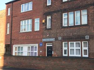 a red brick building with white windows and a door at Spacious Entire Two Double Bedrooms Flat, N 3 in Great Yarmouth