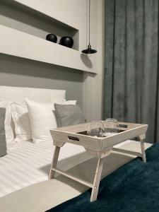 une table basse en bois assise à côté d'un lit dans l'établissement Calma Suite (Cielo suites), à Kavala