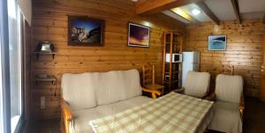 シエラネバダにあるCasita de madera Alpes 6の白い椅子2脚と木製の壁が備わる客室です。