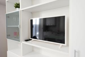 uma televisão de ecrã plano numa parede branca em L'Angolo Giallo - Centralissimo San Benedetto del Tronto em San Benedetto del Tronto