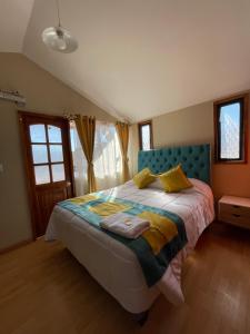 Schlafzimmer mit einem Bett mit blauem Kopfteil in der Unterkunft Hotel Cecil in Vallenar