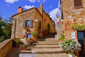 an old stone building with stairs and flowers at Pienzalettings in Pienza