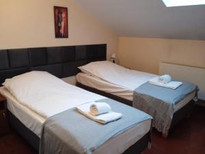 2 camas con toallas en una habitación en Centrum Konferencyjne Sułtan en Marki