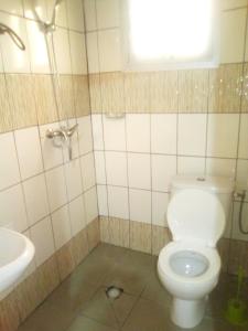 a bathroom with a white toilet and a sink at Résidence Cristal Logpom in Douala