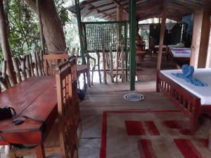 a room with two beds and a table in a house at River Side Cabana in Tissamaharama