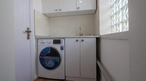 a white kitchen with a washing machine and a window at Hotel type rooms on avenue Melikishvili, city center in Tbilisi City