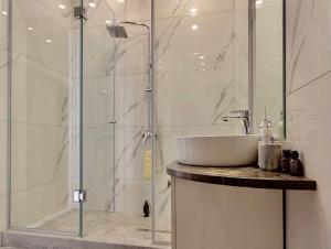 a bathroom with a sink and a glass shower at Hotel type rooms on avenue Melikishvili, city center in Tbilisi City +23 photos