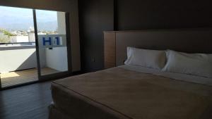 a bedroom with a large bed and a large window at H1 Apartments Hotel in San Fernando del Valle de Catamarca
