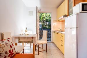 a kitchen with a table and a dining room at Apartments Tolic in Baška Voda +73 photos