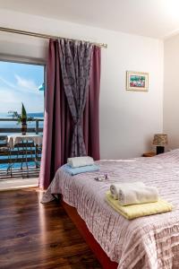 a bedroom with a bed with a view of the ocean at Apartments Tolic in Baška Voda