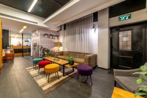 فندق ديزنغوف أفينيو البوتيكي في تل أبيب: غرفة معيشة مع طاولة وكراسي ملونة