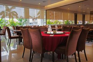 comedor con mesa roja y sillas en DeHome Boutique Hotel, en Kuching