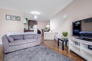 a living room with a couch and a flat screen tv at Stylish 2Bed Apartment-City Centre - Free Parking. in Birmingham