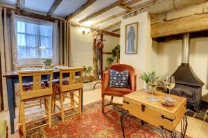 a living room with a table and a fireplace at Tudor Cottage by Spa Town Property - Historic Charm in Warwick Town Centre in Warwick