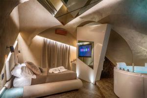 um quarto com uma cama, uma televisão e uma banheira em Le Suites Del Duomo Luxury em Catânia