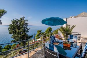 a balcony with a table and chairs and an umbrella at Apartments Tolic in Baška Voda