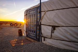 a door to a tent with the sunset in the background at Family Style Star gazing Yurt in Twentynine Palms