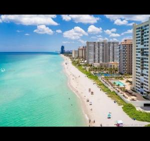 a view of a beach with buildings and the ocean at Art Deco Themed Vacation Home w Sauna, Huge Terrace, & Outdoor BBQ Kitchen in Hallandale Beach