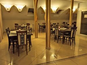 a dining room with tables and chairs and lights at Centrum Konferencyjne Sułtan in Marki
