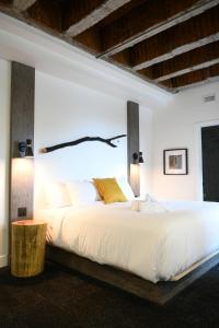 a bedroom with a white bed and white walls at Hotel Le Bloc in Quebec City