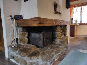 a stone fireplace in a living room with at Haldi Apartment in Klosters Serneus