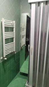 ein Badezimmer mit einem Spiegel und einer grün gefliesten Wand in der Unterkunft Napolì B&B in Neapel