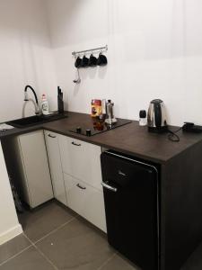 a kitchen with a black and white counter top at Apartamenty LENA 4 in Racibórz