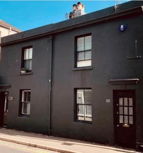 a black building with windows on a street at CENTRAL LOCATION Modern North Lanes Holiday Cottage with a Private Patio in Brighton & Hove