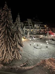 a resort with snow covered trees and a building at Apartments Konaci Centar in Kopaonik