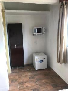 a kitchen with a refrigerator and a microwave on the wall at Departamentos LT3 in Las Toscas