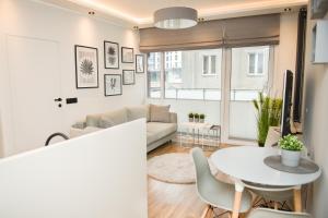 a living room with a table and a couch at Beautiful Days in Lodz in Łódź