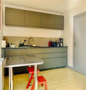 cocina con mesa y 2 sillas rojas en La Villa Maranges - Maison de Rêve, en Dezize-lès-Maranges