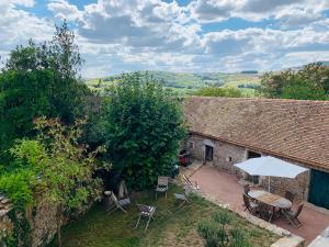 un patio al aire libre con mesa, sillas y sombrilla en La Villa Maranges - Maison de Rêve, en Dezize-lès-Maranges