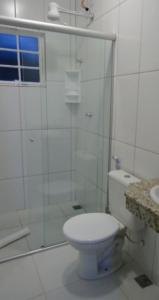 La salle de bains est pourvue de toilettes et d'une douche en verre. dans l'établissement POUSADA VILA DO BIRIBIRI, à Diamantina