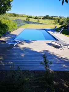 a swimming pool with two chairs on a patio at Ô'bel Écrin in Aubel