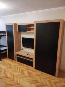 uma sala de estar com uma televisão e uma secretária e um quarto com em Тисовець квартира em Tysovets