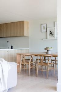 una cucina e una sala da pranzo con tavolo e sedie in legno di Noosa Court Apartment 4, Noosa Heads a Noosa Heads