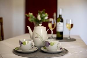 a table with two tea cups and a bottle of wine at Apartment Zivkovic in Rogoznica