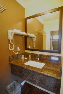 a bathroom with a sink and a large mirror at Studio City Inn - Near Universal Studios Hollywood in Los Angeles