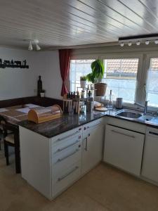 a kitchen with white cabinets and a counter top at Backpacker Bären in Urnäsch