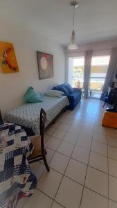 een slaapkamer met 2 bedden en een woonkamer bij Ponta Negra_Apto Completo in Natal