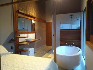 a large bathroom with a tub and a bed at El Shadday Pousada Boutique in Ubatuba