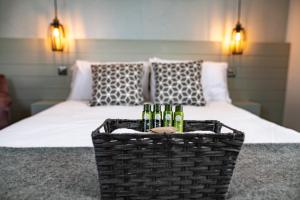 a basket with bottles of wine in front of a bed at Nitehouse in Reading