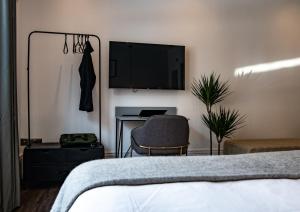 a bedroom with a bed and a desk and a television at Nitehouse in Reading