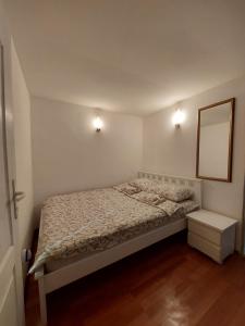 una piccola camera da letto con un letto e uno specchio di Borsko jezero a Bor