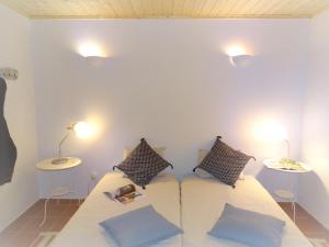 a bedroom with a bed with pillows and two tables at QUINTA DAS TEIMOSAS by Stay in Alentejo in Cercal